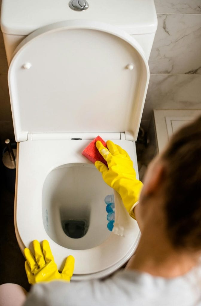 woman cleaning a toilet