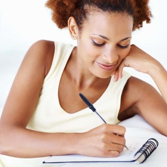 woman writing a to-do list in a notebook