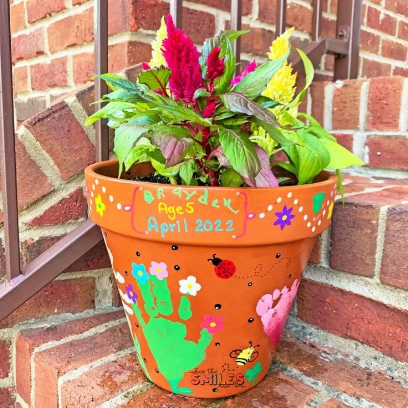flower pot decorated with handprints and other embellishments