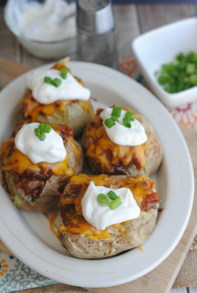 These BBQ Pork Baked Potatoes are absolutely delicious! Use our BBQ pork recipe (so easy to make in the slow cooker!) or use your own.