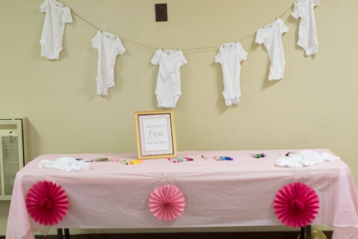 pink and gold baby shower onesie decoration station