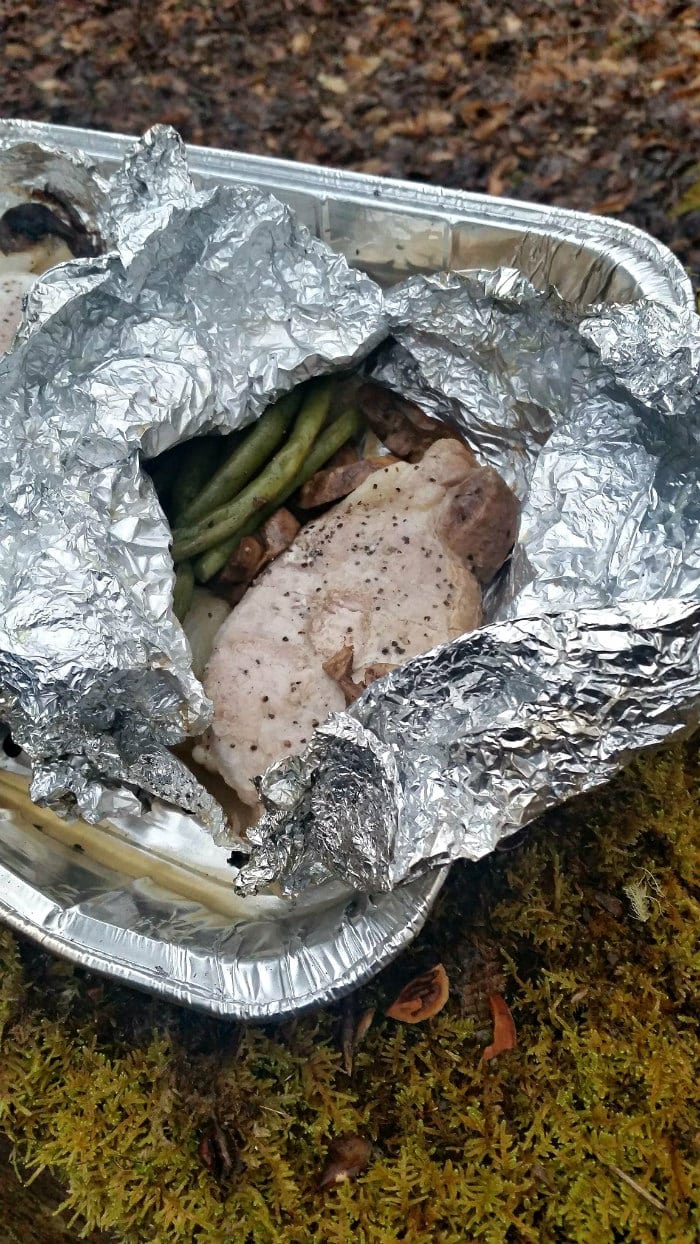 Pork chop foil packets on a campfire