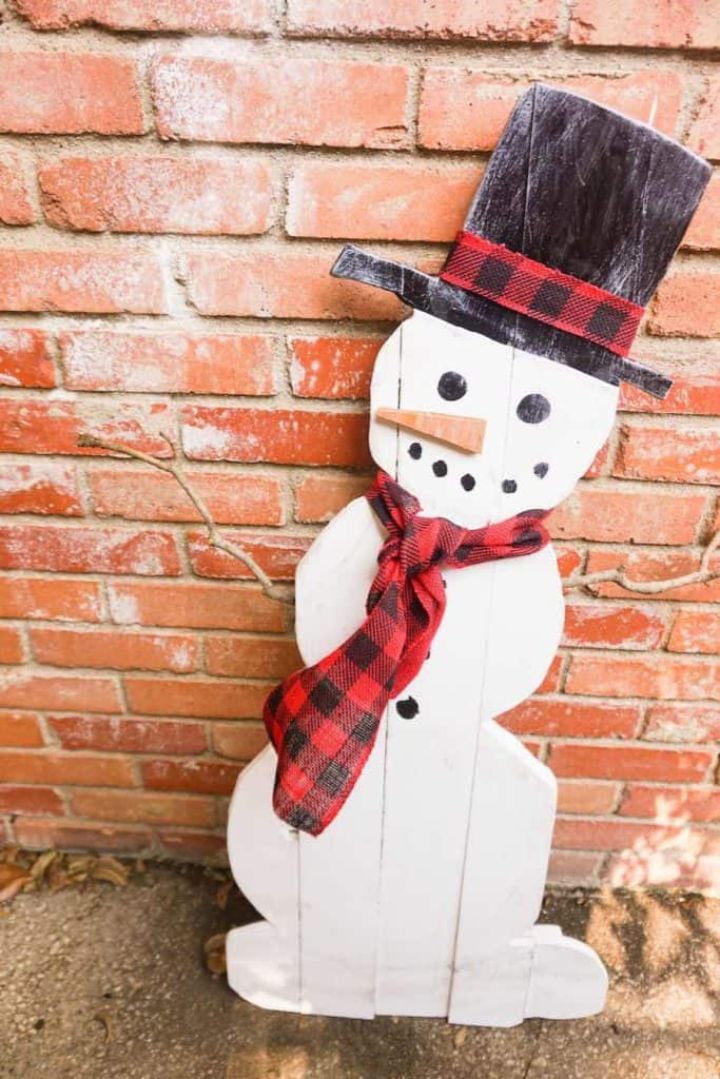 wooden snowman against a brick background