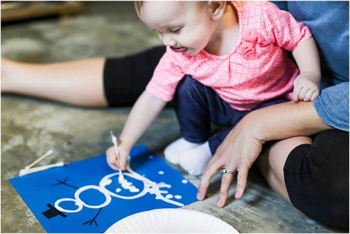 child painting a snowman with a q-tip