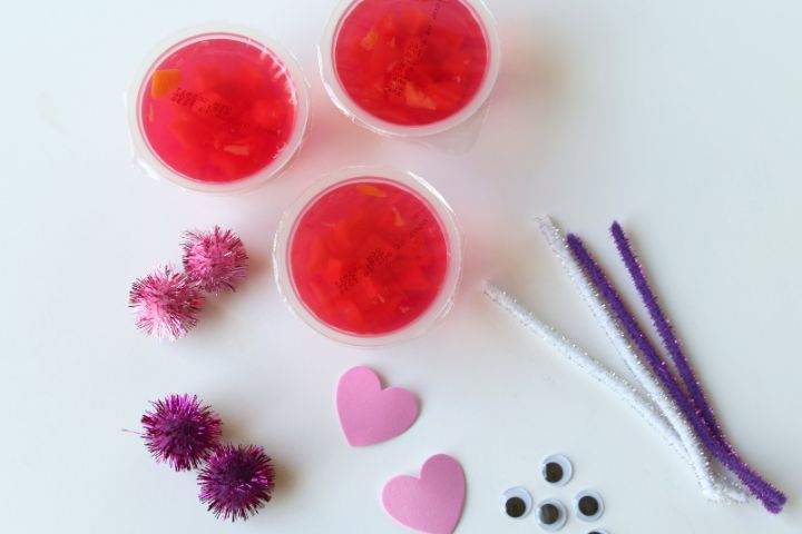 pipe cleaners, pom poms, foam hearts, fruit cups on a white background