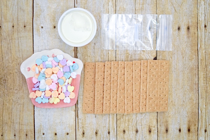 conversation hearts, white icing, graham crackers, and a plastic bag