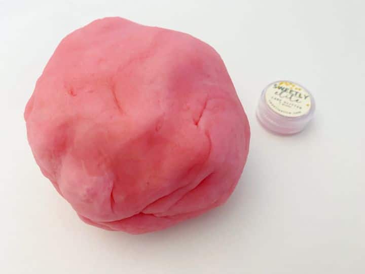ball of pink playdough on white background