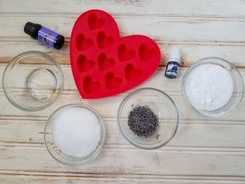 materials for the lavender shower melts - heart mold, lavender essential oil, baking soda, epsom salts, and soap colorant