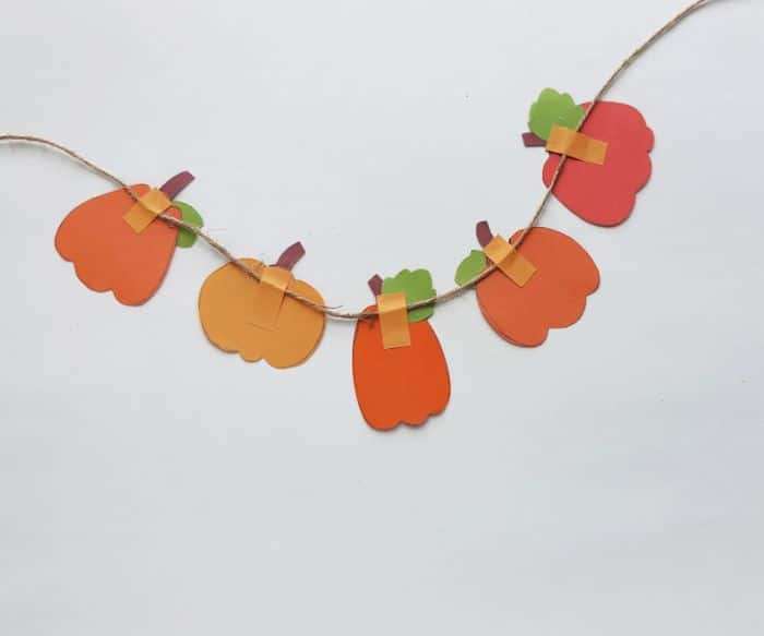 adding pumpkins to the garland