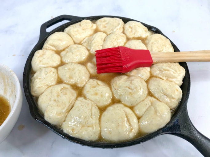 applying the brown sugar mixture to the unbaked eggnog cinnamon rolls