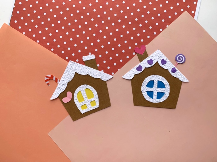 two paper gingerbread houses on pink scrapbook paper