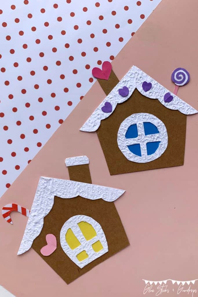 two paper gingerbread houses on light pink background