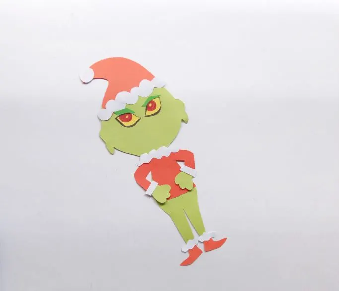gluing eyes and eyebrows on the Grinch's face