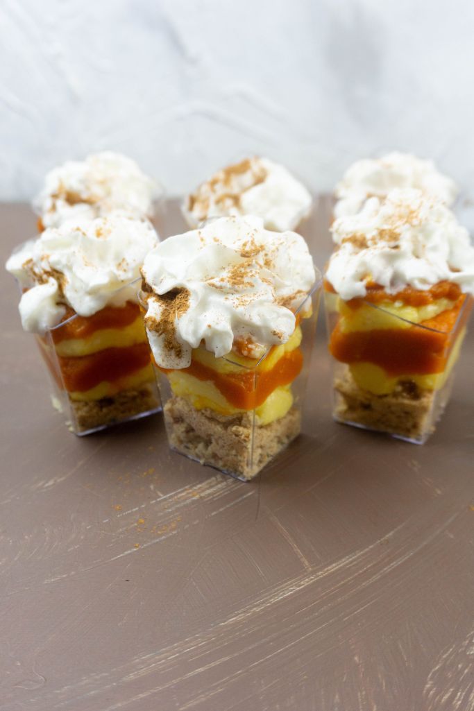 mini pumpkin trifles on brown tabletop with white background