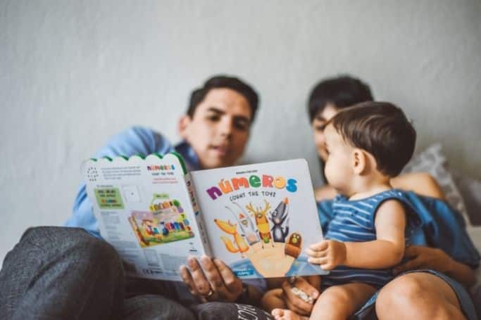 dad and mom reading to child