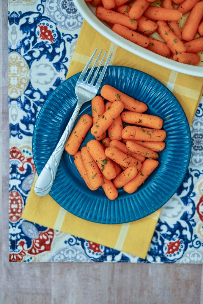 finished carrots on a blue plate with large serving fork