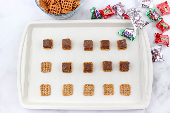pretzels on parchment paper with chocolates added