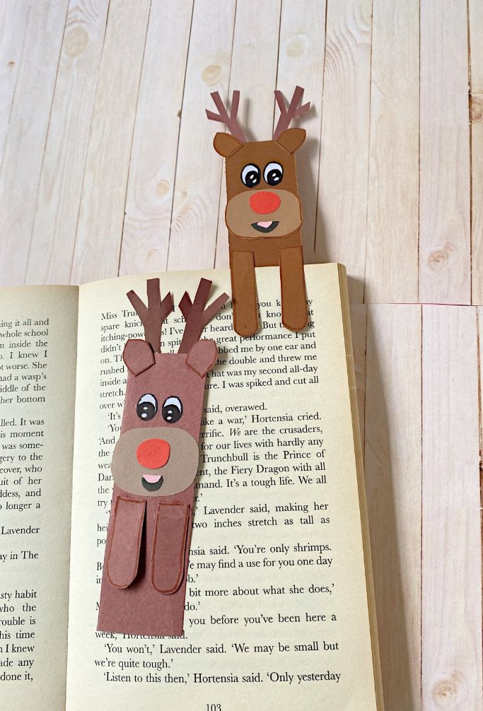 cute reindeer bookmarks with one holding a page and the other lying on top of the page