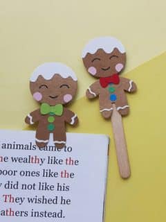 two gingerbread man bookmarks on a yellow background