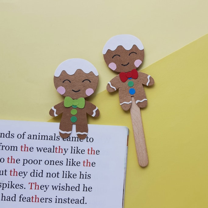 two gingerbread man bookmarks on a yellow background