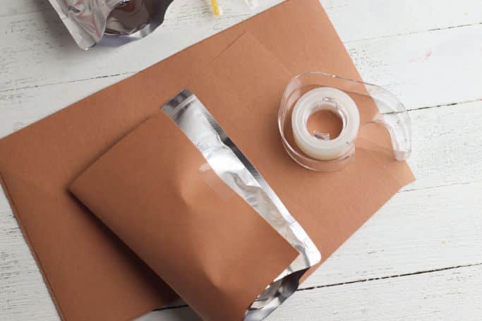 covering the juice pouches with brown paper