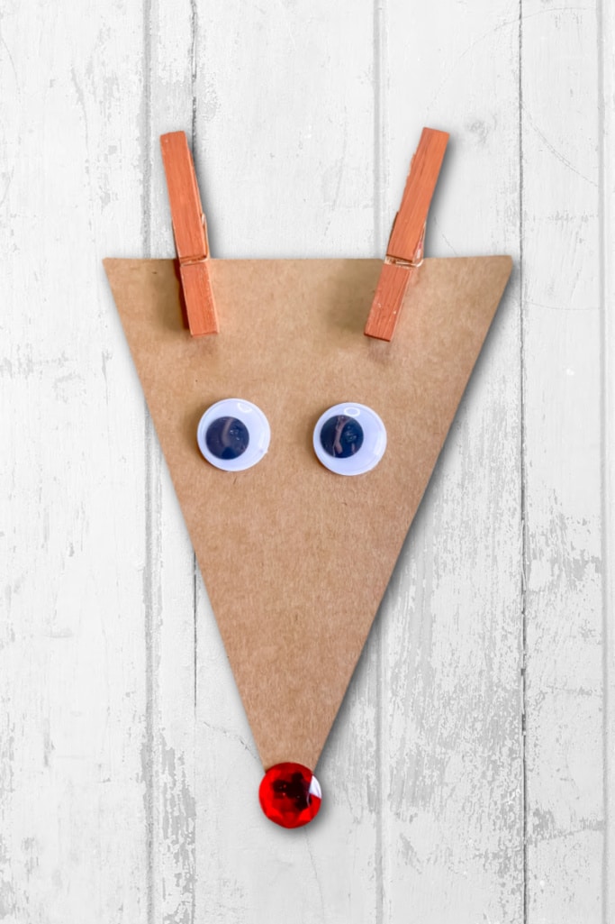 Rudolph craft for kids on white wood background