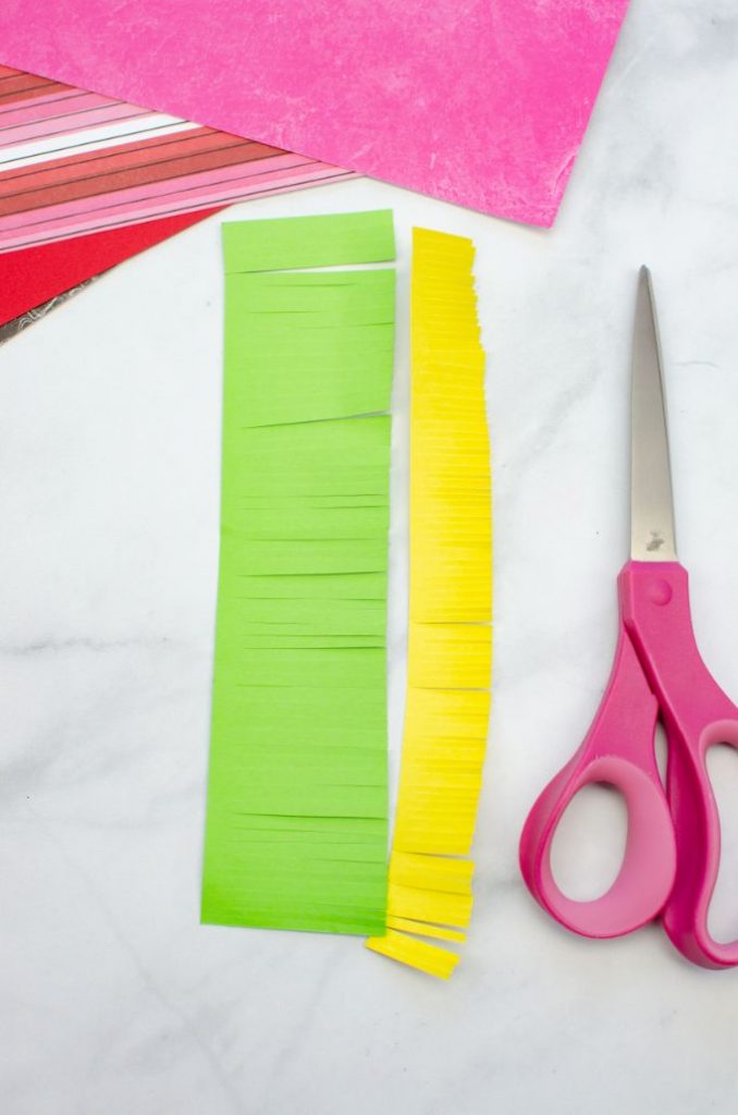cutting fringe on yellow and green paper