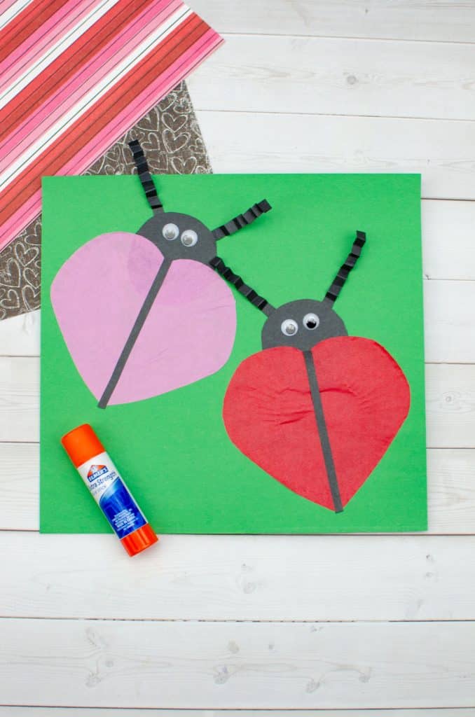 adding ladybugs to the green paper