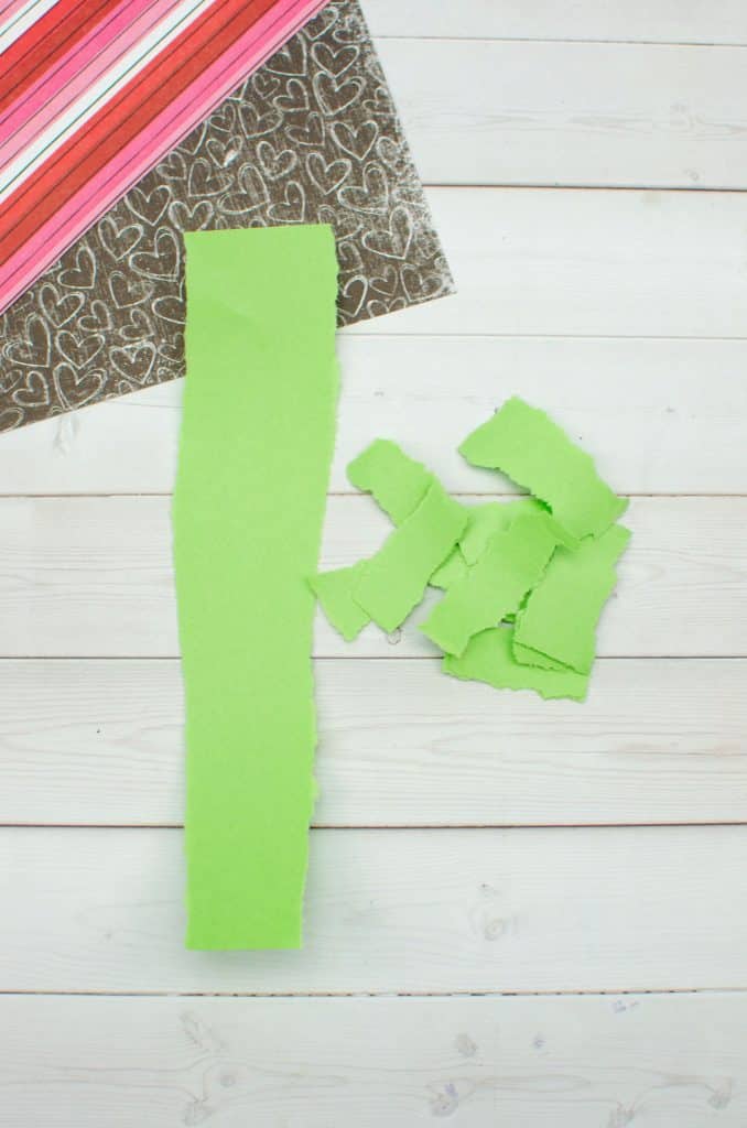 tearing light green paper into small strips