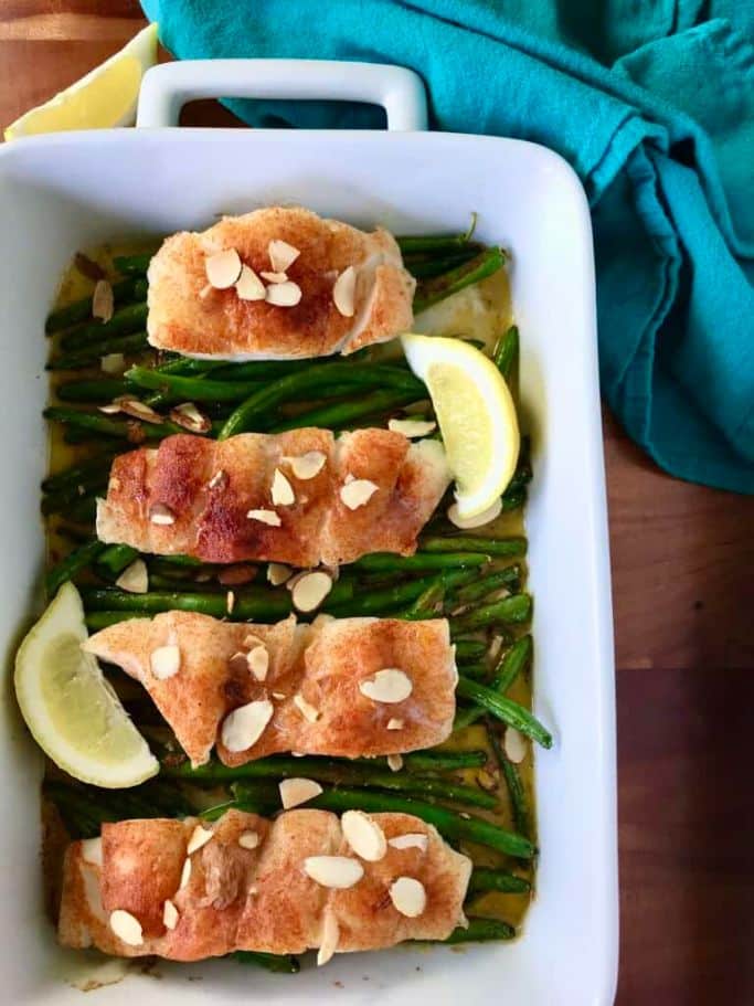 spiced cod and green beans in white baking dish