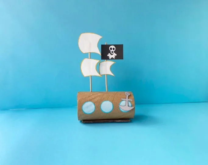 diy pirate craft - a ship made out of a cardboard tube, paper, and sticks