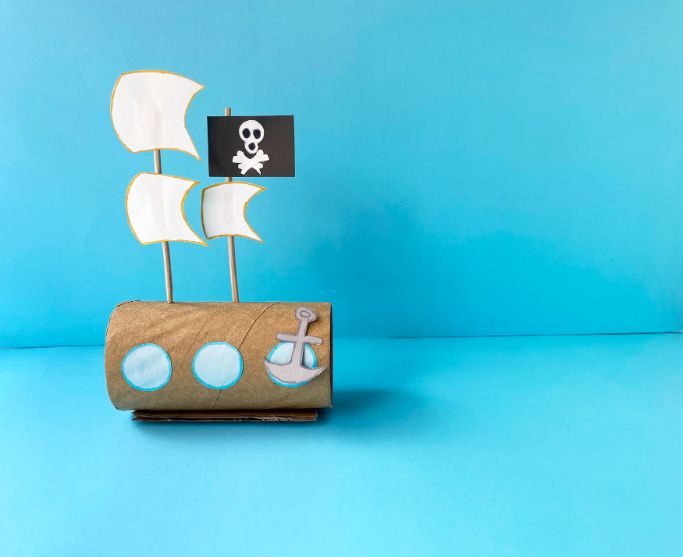 a pirate ship made out of a toilet paper roll on a blue background