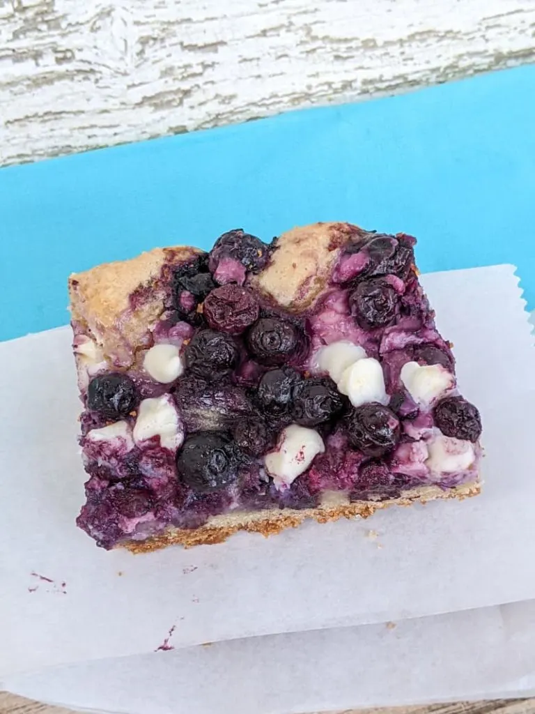 a blueberry and cream cheese bar on parchment paper