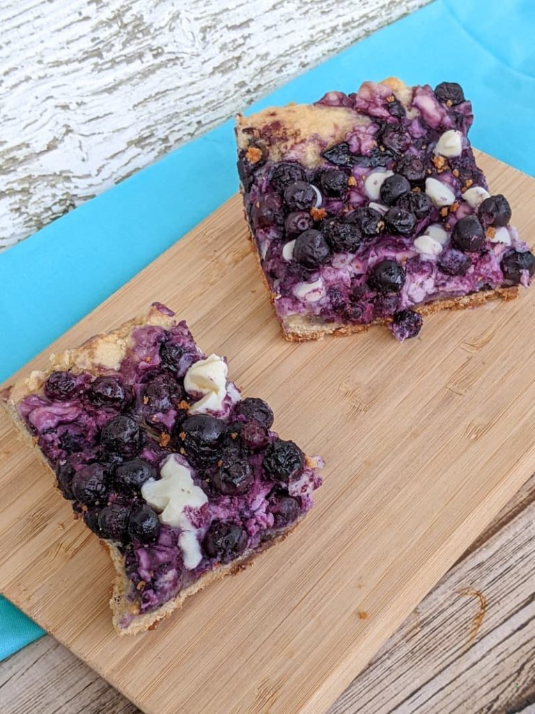two blueberry bars with cream cheese and white chocolate chips