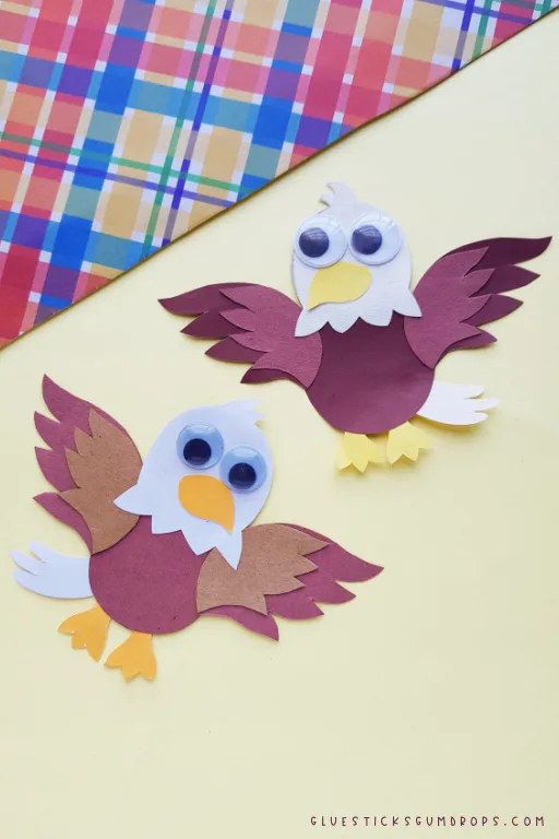 two paper bald eagles on light yellow background