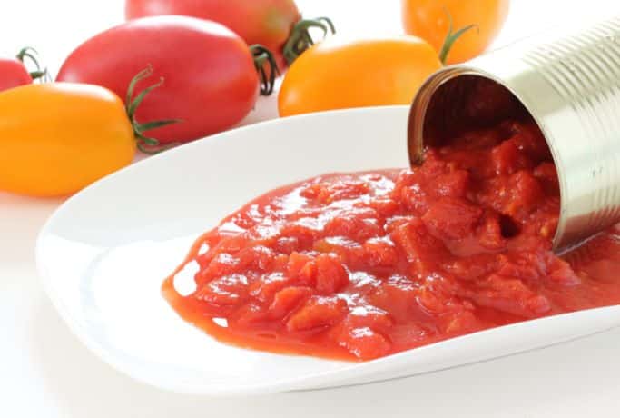 can of diced tomatoes spilling onto white dish