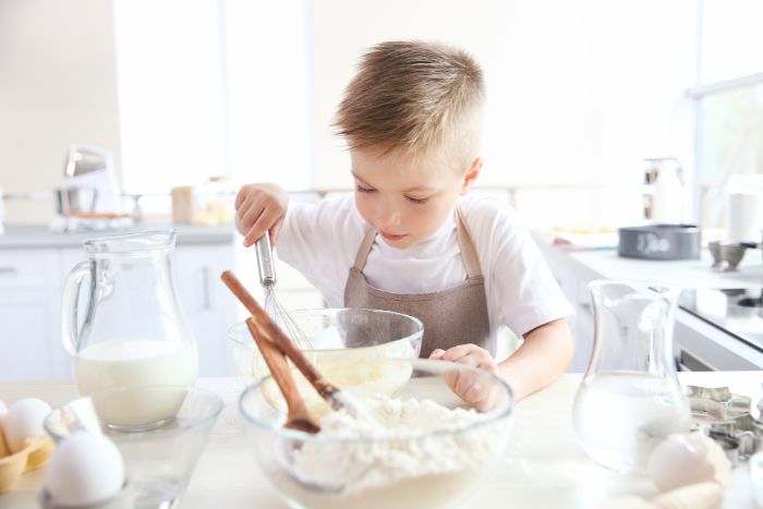child mixing ingredients in the kitchen