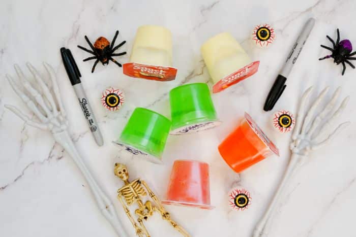 vanilla pudding cups, lime gelatin cups, orange gelatin cups, Sharpie markers with spooky decorations