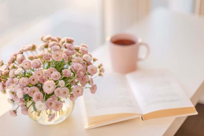 cup of coffee and flowers with a book