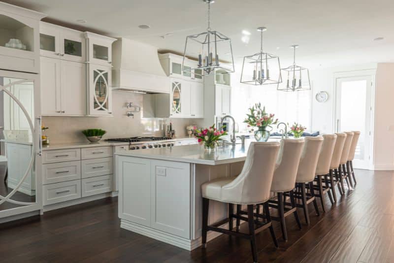 beautiful white kitchen with seating at eat in bar