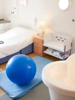 birthing room with birthing ball, tub, and bed