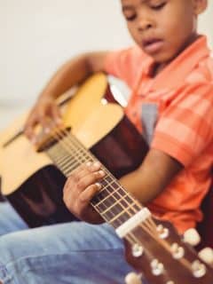 boy learning to play guitar