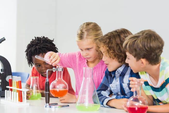 kids pouring liquid into flasks