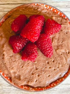 chocolate peanut butter protein pudding topped with raspberries