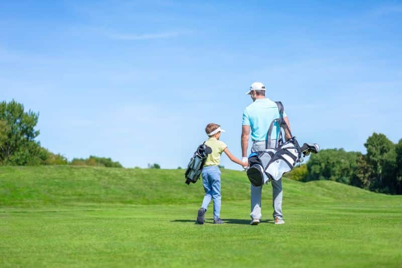 dad and son on golf course