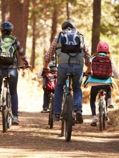 family riding bikes through a forest