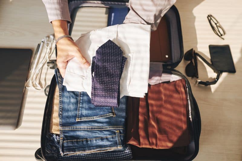 man packing suitcase for business trip
