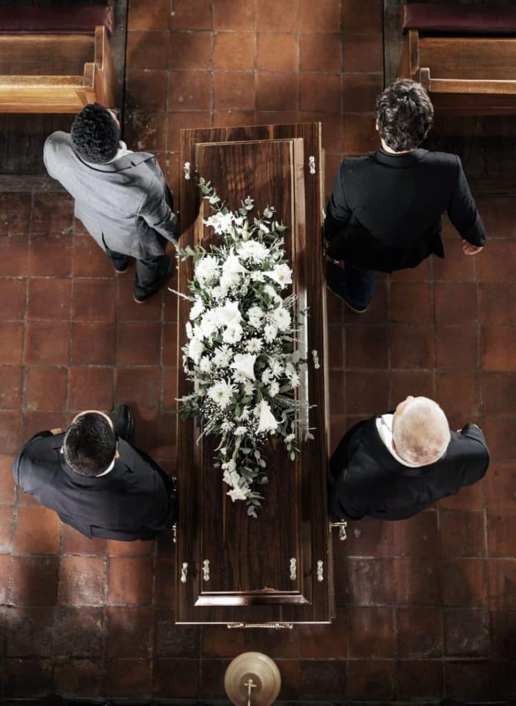 4 men carrying a casket