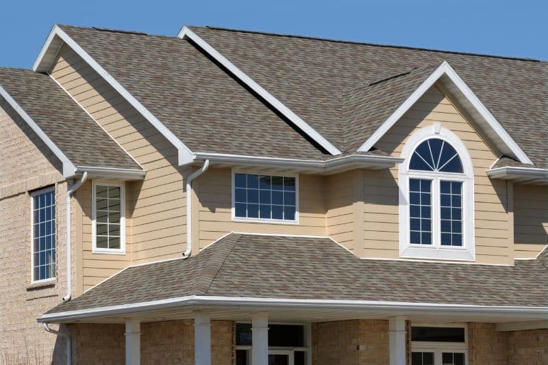 beige house with shingled roof