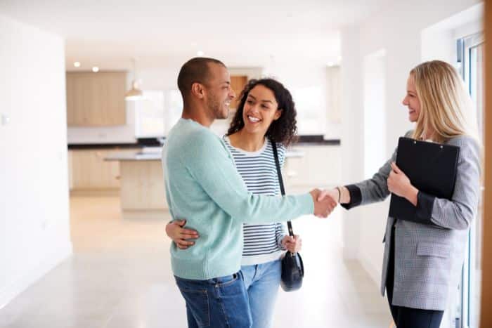 realtor shaking hands with couple